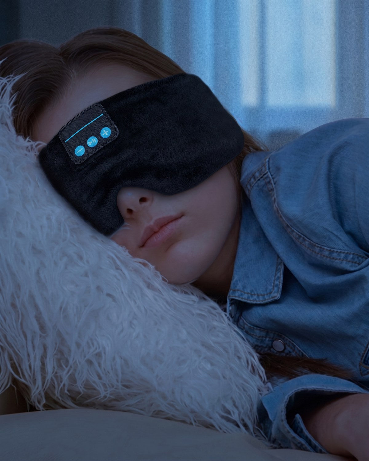 A woman asleep on her side, cheek on the pillow, wearing the Dual-Clearance Sleep Mask in Midnight Black.