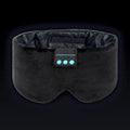 The Dual-Clearance Sleep Mask in Midnight Black, front on: wide black velvet band, two molded eye cups, dark satin lining inside and the three-button control panel.